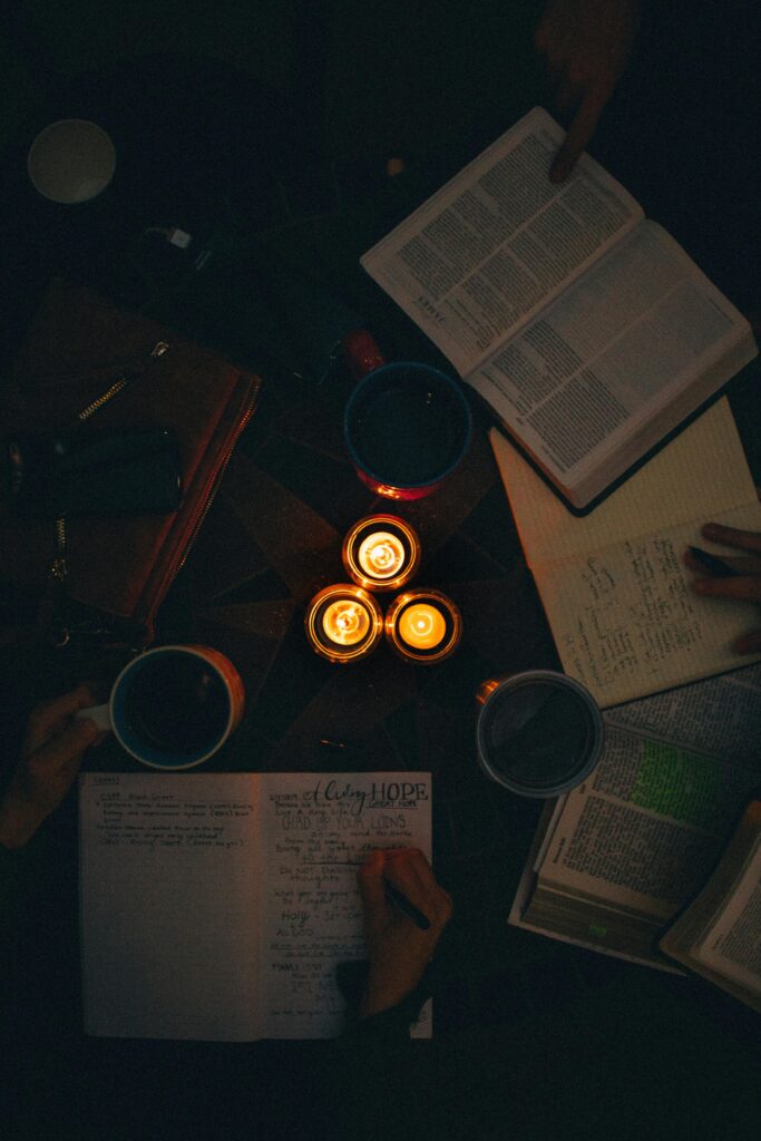 A moody, candle-lit study session with open books and notes, perfect for cozy learning vibes.